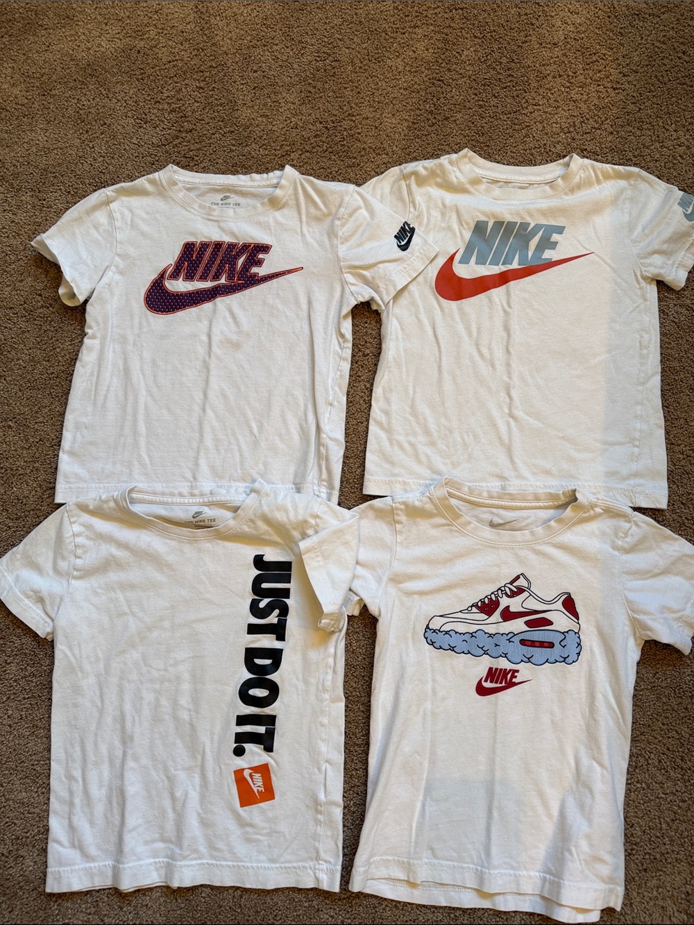 4 x Nike White Kids Short Sleeve Tees with Blue, Red and Orange Logos.